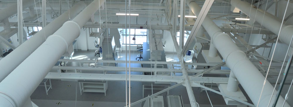 Overhead view of ALS TDI's core lab facility, showing ductwork and infrastructure above the workspace.